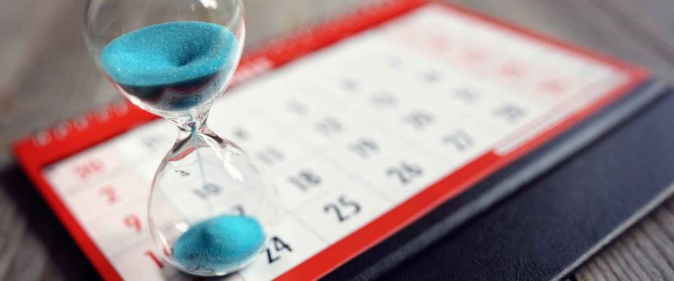 Glass clock concept on calendar for time lost away from important date, schedule and deadline